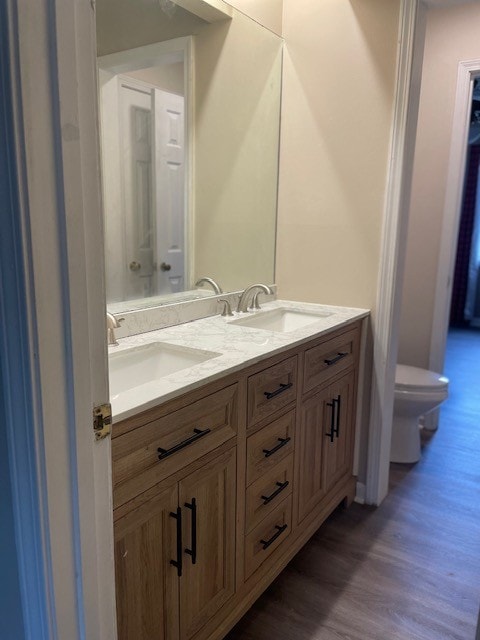 bathroom with vanity, hardwood / wood-style floors, and toilet