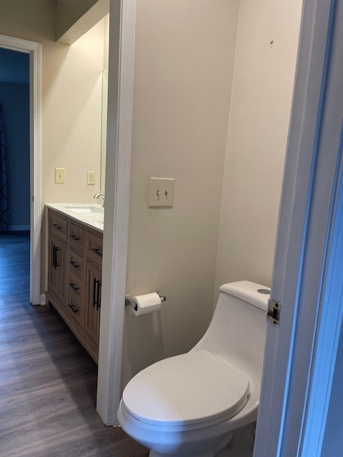 bathroom featuring hardwood / wood-style floors, vanity, and toilet