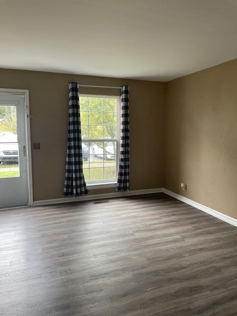 empty room with dark hardwood / wood-style flooring