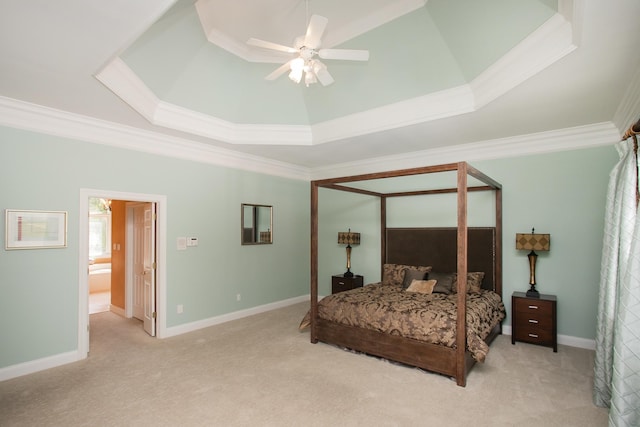 carpeted bedroom with ensuite bath, crown molding, ceiling fan, and a raised ceiling