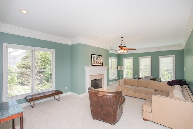 living room featuring ceiling fan, ornamental molding, light carpet, and a tiled fireplace