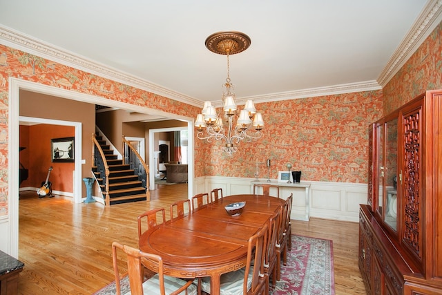 dining room featuring an inviting chandelier, crown molding, and light hardwood / wood-style floors