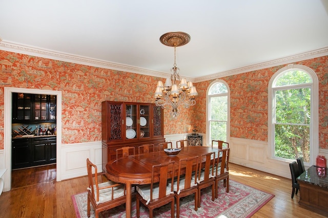 dining room with crown molding, a chandelier, and wood-type flooring