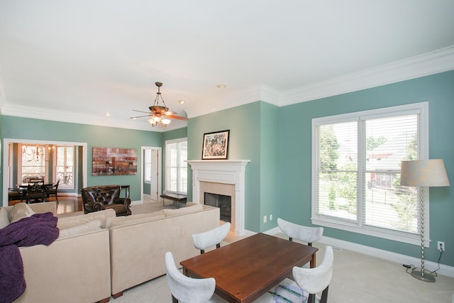 carpeted living room with ceiling fan, a tile fireplace, and a healthy amount of sunlight