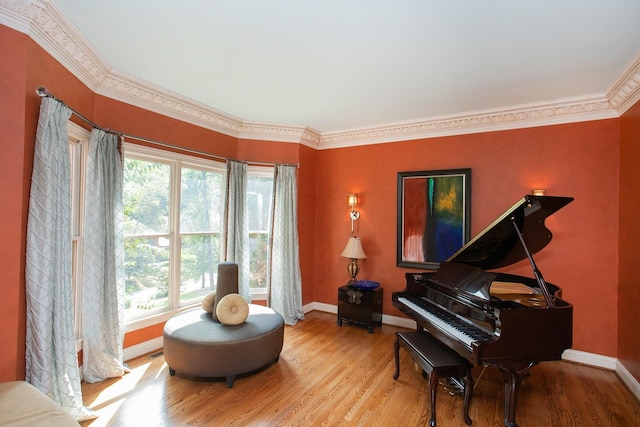 sitting room with light wood-type flooring, crown molding, and a wealth of natural light