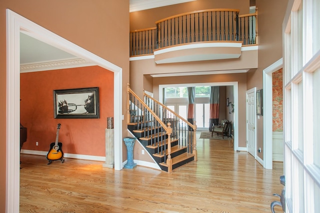 entryway with crown molding and light hardwood / wood-style floors