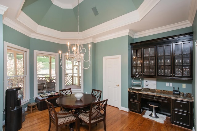 dining room featuring ornamental molding, a chandelier, and light hardwood / wood-style flooring