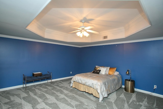 carpeted bedroom with ceiling fan, a tray ceiling, and ornamental molding