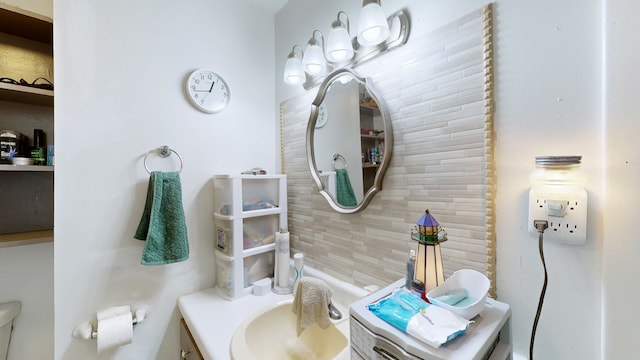 bathroom with vanity, backsplash, and toilet