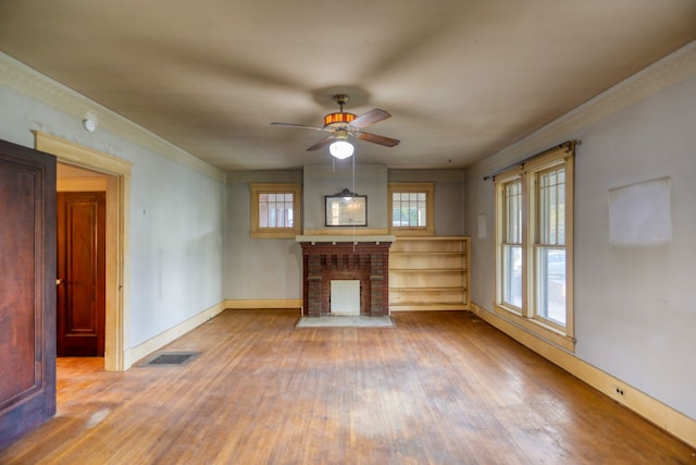 unfurnished living room featuring hardwood / wood-style floors, ceiling fan, and a fireplace