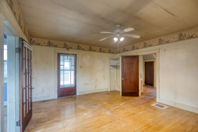 unfurnished room with visible vents, ceiling fan, baseboards, and wood finished floors