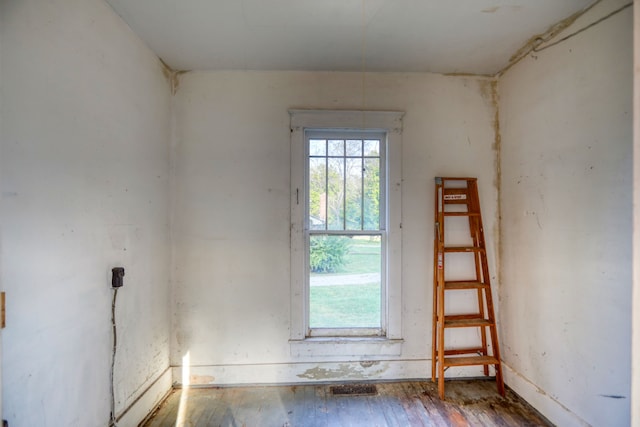 spare room featuring hardwood / wood-style floors, plenty of natural light, and visible vents