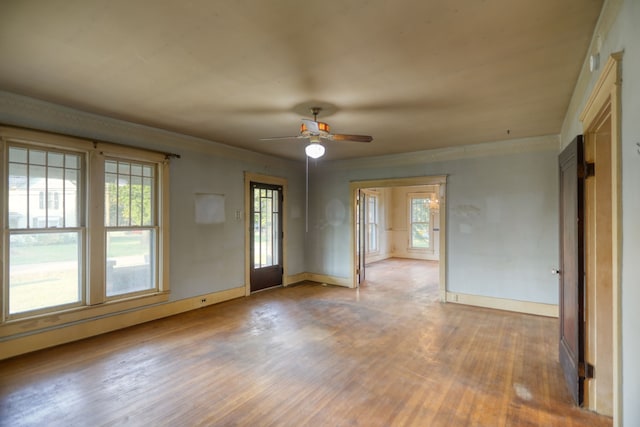 spare room featuring plenty of natural light, crown molding, and wood finished floors