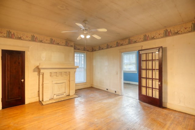 unfurnished living room with a wealth of natural light, french doors, ceiling fan, and hardwood / wood-style flooring