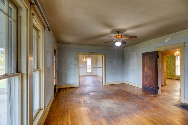 spare room featuring a ceiling fan, wood finished floors, visible vents, and baseboards