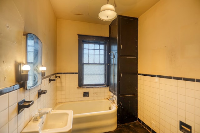 bathroom featuring a washtub, sink, and tile walls