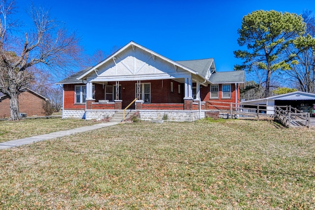 view of front of property featuring covered porch, brick siding, and a front yard