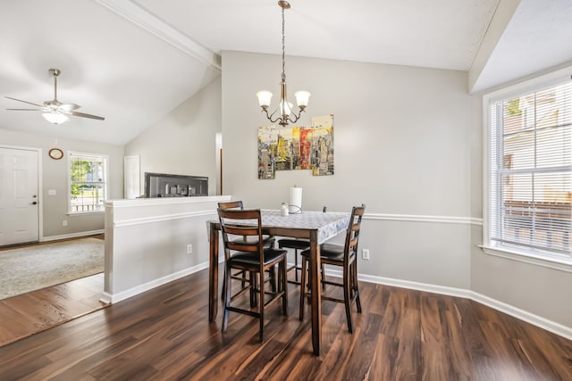 dining room with ceiling fan with notable chandelier, lofted ceiling, and dark hardwood / wood-style floors