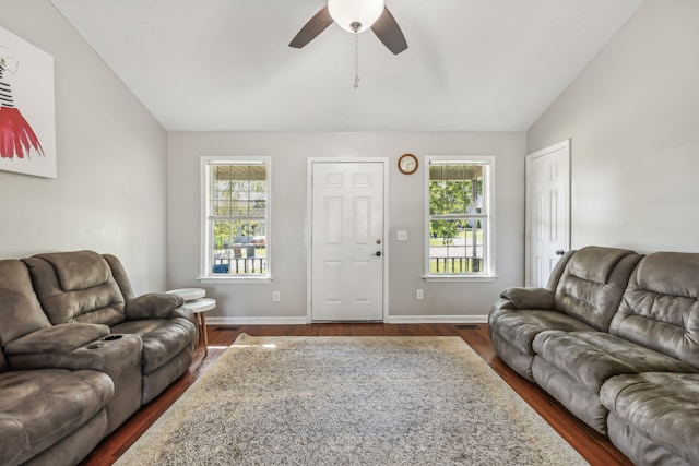 living room featuring dark wood-type flooring, vaulted ceiling, and a healthy amount of sunlight