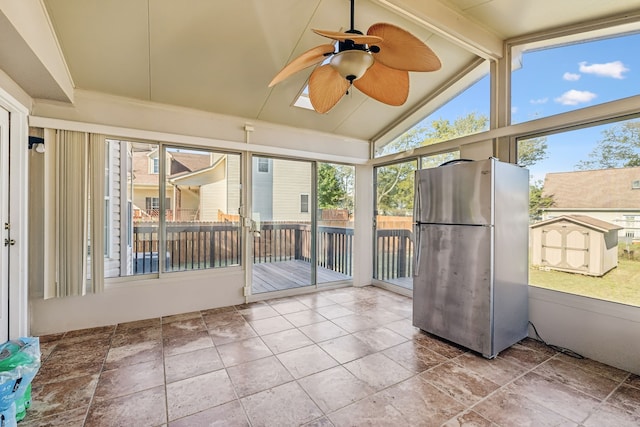 unfurnished sunroom featuring lofted ceiling with beams and ceiling fan