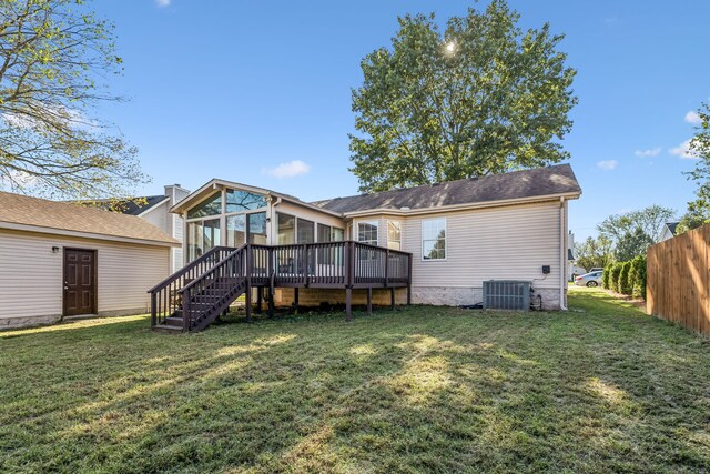 back of property with a wooden deck, central AC unit, and a lawn