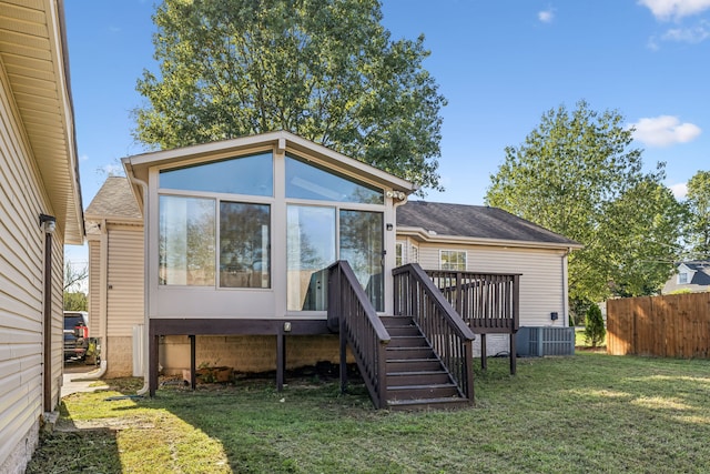 rear view of property with central AC, a lawn, and a deck