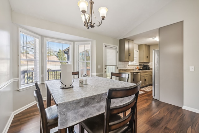 dining space with a notable chandelier, lofted ceiling, and dark hardwood / wood-style flooring