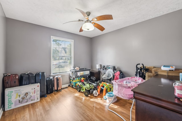 interior space with light hardwood / wood-style flooring, a textured ceiling, and ceiling fan