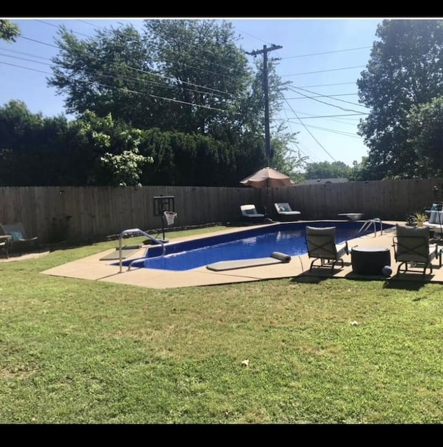 view of swimming pool featuring a yard and a diving board