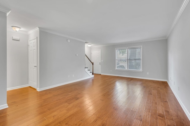 unfurnished living room with ornamental molding and light wood-type flooring