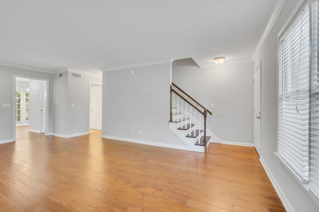 unfurnished room featuring ornamental molding and light hardwood / wood-style flooring