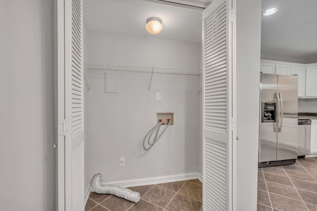 laundry area featuring dark tile patterned floors and hookup for a washing machine