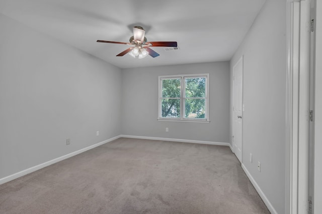 spare room featuring light colored carpet and ceiling fan