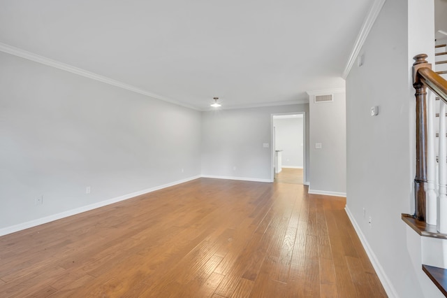 empty room featuring crown molding and light wood-type flooring