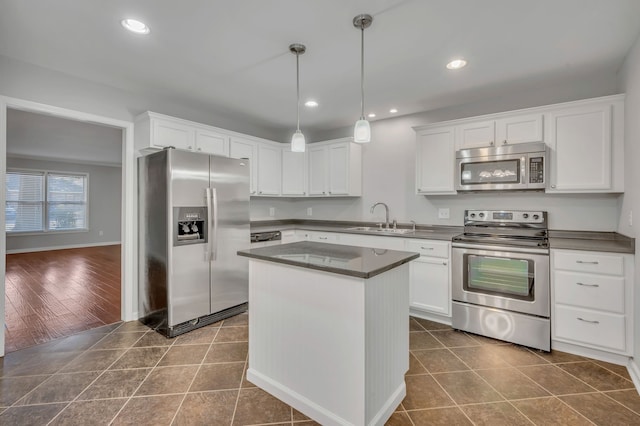 kitchen with sink, dark wood-type flooring, white cabinetry, stainless steel appliances, and a center island