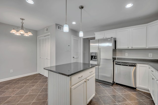 kitchen with a kitchen island, pendant lighting, white cabinetry, an inviting chandelier, and appliances with stainless steel finishes