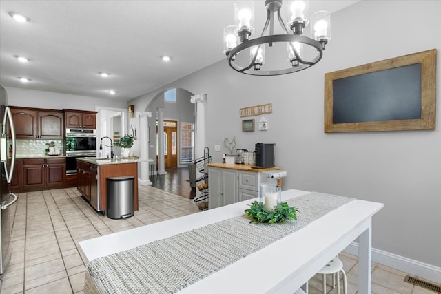 tiled dining space featuring sink and an inviting chandelier