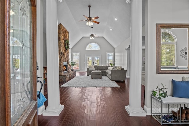 foyer featuring decorative columns, ceiling fan, high vaulted ceiling, a fireplace, and dark hardwood / wood-style floors