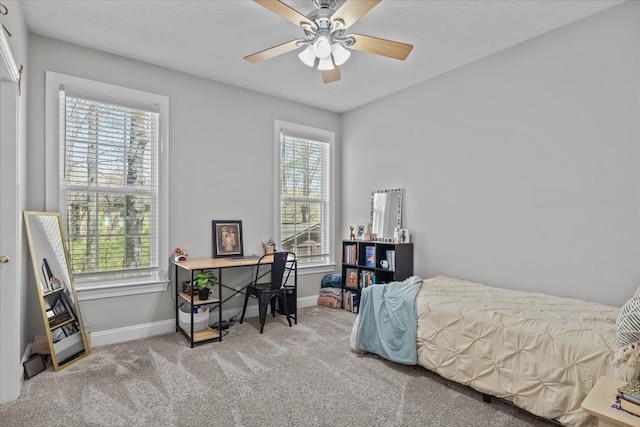 carpeted bedroom with multiple windows and ceiling fan