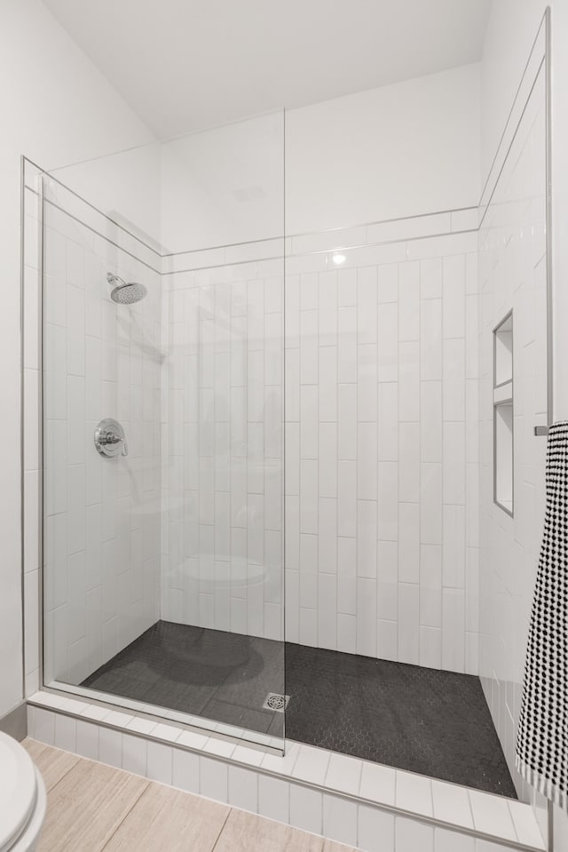 bathroom featuring wood-type flooring and a shower with door