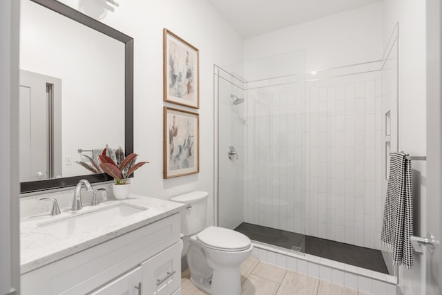 bathroom featuring vanity, tiled shower, and toilet