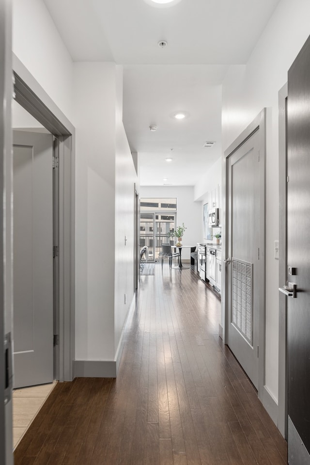 corridor with hardwood / wood-style flooring