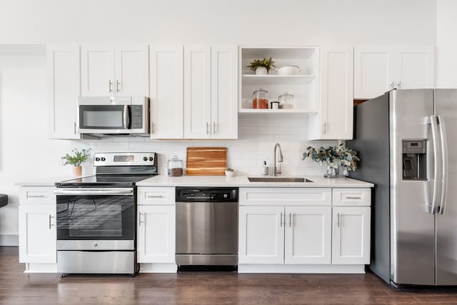 kitchen with white cabinets, sink, tasteful backsplash, appliances with stainless steel finishes, and dark hardwood / wood-style flooring