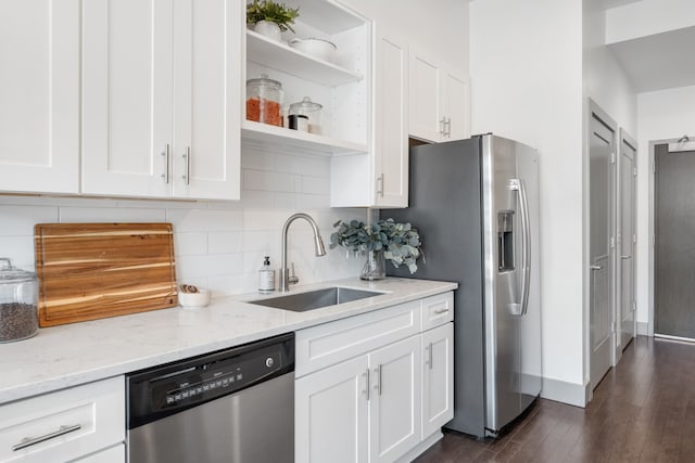 kitchen with white cabinets, sink, stainless steel appliances, dark hardwood / wood-style floors, and light stone countertops