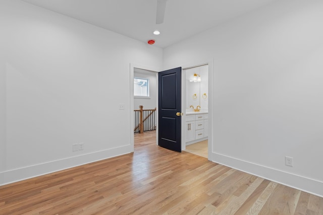 unfurnished bedroom featuring ensuite bathroom, ceiling fan, and light hardwood / wood-style floors