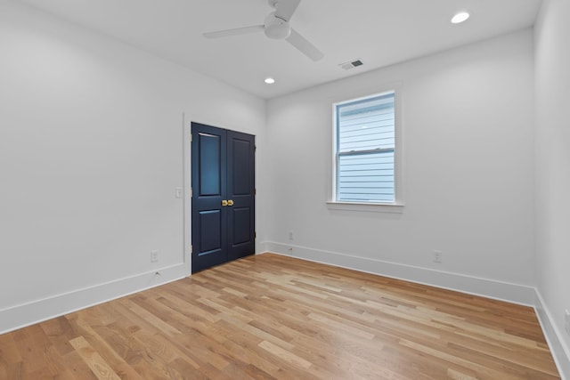 empty room with ceiling fan and light hardwood / wood-style floors