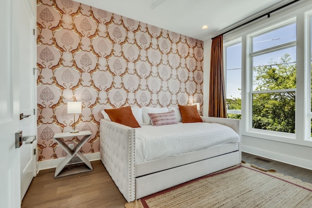 bedroom featuring hardwood / wood-style floors and multiple windows