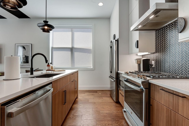 2176 Carson St Unit 23, Nashville, TN 37211 - kitchen with stainless steel appliances, wall chimney exhaust hood, tasteful backsplash, light countertops, and light wood-style floors