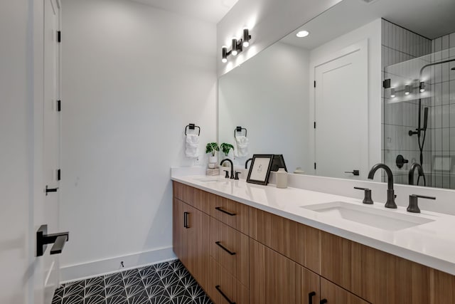 bathroom with tile patterned flooring, a tile shower, and vanity