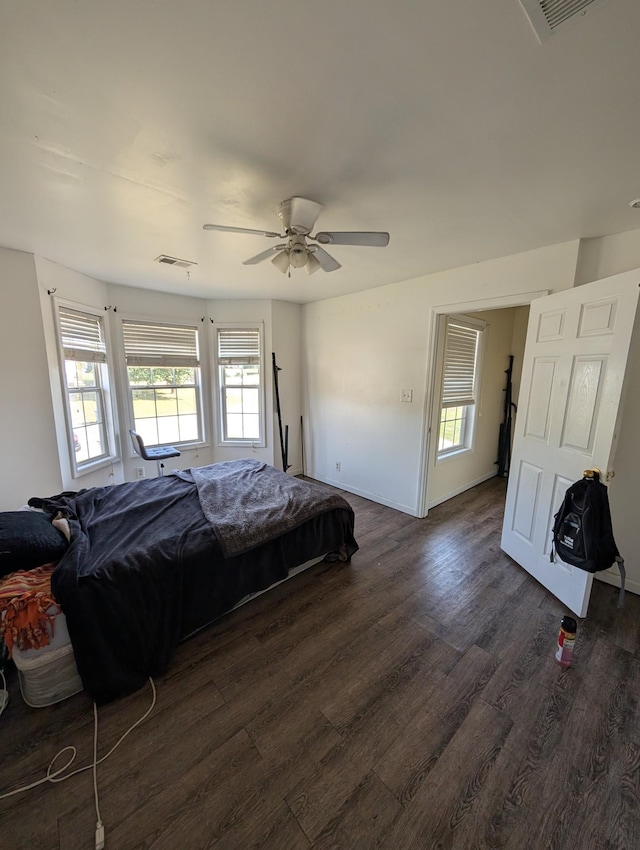 bedroom with ceiling fan, baseboards, dark wood-style floors, and visible vents